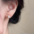 Sparkling square iridescent diamond earrings in golden finish on model's ear - Gold White Zirconia