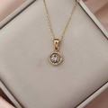Close-up of golden necklace featuring a pink zircon pendant surrounded by white crystals - Gold Pink Zirconia