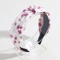 Close-up of pink floral fabric knot headband on a clear display stand with soft shadows - White Floral Print