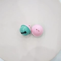 Close-up of dual-tone pink and green 2.2cm metal jingle bells for DIY crafts - Pink & Green