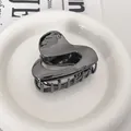 Détail d'une pince à cheveux en métal argenté en forme de cœur avec finition miroir polie - Noir Fusil