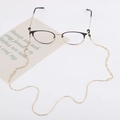 Detail of golden geometric metal chain for glasses and masks on a white background - Gold