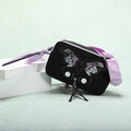 Detail of black matte crossbody bag with butterfly wing prints and purple strap - Black/Purple
