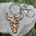 Western leopard bull skull keychain with silver bead trim on natural stone background - Cheetah Print Bull Head