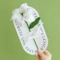 Handmade crochet lily flower with white petals and green leaves on decorative card - Lily - White