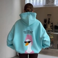 Oversize light blue hoodie with cartoon duck back print in a cozy cafe setting - S / Blue