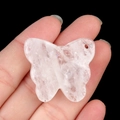 Pink quartz butterfly pendant with natural crystal textures on hand with black background - White Crystal