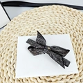 Dettaglio elegante fermaglio per capelli a fiocco nero con strass lucidi su scatola bianca - Strass Grigio Minerale - Forma a 8 Appuntita