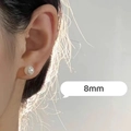 Close-up of a minimalist 8mm white pearl stud earring worn on ear with soft lighting - 8mm