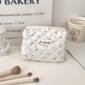 Vue détaillée d'une trousse à maquillage blanche matelassée avec un motif cerise - M / Cerise
