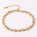 Macro view of gold heart chain bracelet with white enamel evil eyes and zircon stones - 18K Gold / White Blue