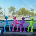 Close-up of flexible alien suction cup toys in four colors on a car dashboard - No Light-Alien-Dark Red