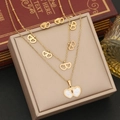 Détail d'un ensemble de collier cœur double couche et boucles d'oreilles dorés sur boîte - Double Cœur