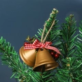 Pair of golden Christmas bells with red plaid bows and berries on a green tree branch - Gold Double Trumpet Bell