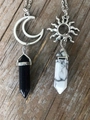 Detail of sun and moon couple necklaces with hexagonal crystals on a wooden background - Black and White 1 Set