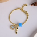 Close-up of 18K gold plated bracelet with evil eye, chili charm and blue bead detail - Blue