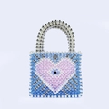 Détail d'un sac cabas perlé à la main avec cœur bleu et motif œil de protection - Bleu saphir