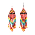 Detailed close-up of handmade bohemian coral pink beaded tassel earrings with fringe - Pink Multicolor