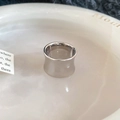 Close-up of a wide polished silver ring with a sleek concave surface and mirror finish - Silver