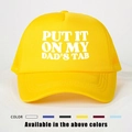 Detail of yellow trucker hat with PUT IT ON MY DAD'S TAB print and mesh back panels - One Size / Yellow