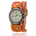 Macro view of vintage bronze watch dial with Roman numerals and rivet leather cuff strap - Orange