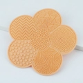 Flower shaped silicone makeup brush cleaning mat in apricot pink with varied textures - Nude