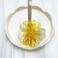 Floral hair claw clip with amber gradient effect on a stylish white wave tray - Yellow (Transparent Lucky Flower)