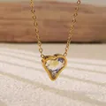 Macro detail of a gold heart pendant necklace featuring a sparkling clear zircon crystal - Clear Heart Necklace (BD021-white)