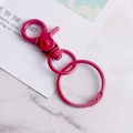 Rose pink lacquered metal lobster clasp key ring with rotating hook on marble surface - Burgundy