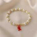 Beaded pearl bracelet with gold beads and a cute red dinosaur charm on silk fabric - Red Dinosaur
