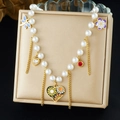 Detail of luxury pearl necklace featuring butterfly, flower and heart enamel charms - Floral Heart Butterfly Style (N3826)