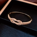 Vue macro d'un bracelet nœud plaqué or serti de zircons blancs dans un coffret velours - Or