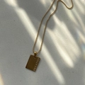 Detailed view of square gold-plated necklace pendant with BREATHE engraving on ball chain - BREATHE / Gold
