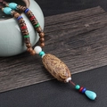 Ethnic style necklace with brown Bodhi pendant and colorful beads in a vintage design - Turquoise Thousand Eye Bodhi