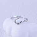 Detail of minimalist wavy stainless steel open ring on a textured artistic background - Steel