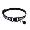 Detail of black nylon pet collar featuring white paw prints with a metal bell and buckle - Black