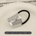 Black elastic hair tie with silver irregular textured metal plate in ceramic tray - Arched Cloud Silver