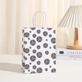White baseball pattern kraft paper gift bag with white twisted rope handles in a home setting - White Volleyball Print Style