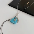 Detail des blauen Glitzer-Handtaschenanhängers mit silbernen Perlenquasten und Kette - Blau