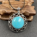 Silver hexagram pendant with turquoise stone and black cord on wooden display - Blue Turquoise (Synthetic)