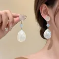 Detail view of the elegant pearl shell pendant earrings with light blue beads on a hook - 21# White Teardrop Shell Pendant (Silver Earring Post)