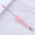 Pink DIY beaded ballpoint pen with metallic accents displayed on a white plush rug - Khaki Light Pink