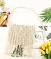 Detail of bohemian straw crossbody bag with geometric weaving and decorative long tassels - White