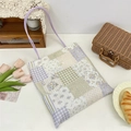 Gros plan du sac fourre-tout patchwork aux motifs floraux avec des anses de couleur lilas - Grille Violette Ajourée