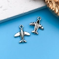 Vintage silver airplane charms for DIY jewelry making shown on a blue background - Small Transport Airplane 13.4x15.6mm