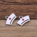 Nurse hat enamel charm pendant with red cross detail on textured wood background - Nurse Hat / Silver/White