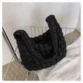 Detail of black quilted cloud shoulder bag with textured puffy fabric in a metal cart - Large / Black
