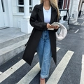 Elegante trench nero lungo da donna abbinato a jeans per un look urbano autunnale di tendenza - S / Nero