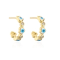 Detailed view of 18K gold C-shaped earrings with blue evil eye heart and zircon stones - Blue Heart Evil Eye