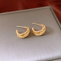Dettaglio degli orecchini incrociati placcati in oro con zirconi su una scatola portagioie - Placcato Oro Reale (Oro) / Oro